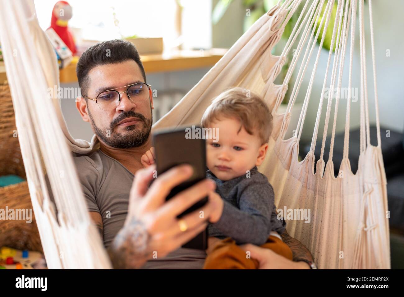 Bleiben Sie zu Hause Papa auf dem Smartphone ignorieren Kind Stockfoto