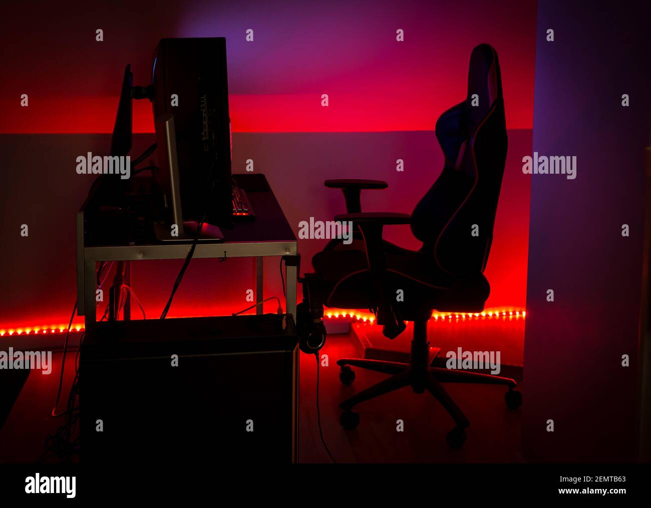 Modernes rotes LED-Umgebungslicht rund um Gaming-Computer zu Hause. Wohnkonzept. Stockfoto