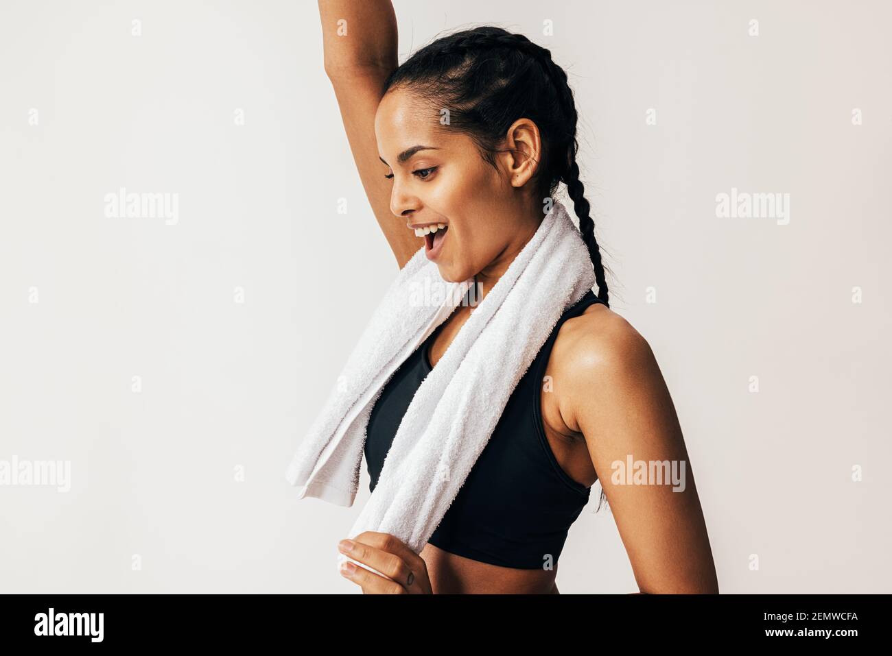 Seitenansicht einer glücklichen Mixed-Race-Frau mit einem weißen Handtuch um den Hals Stockfoto
