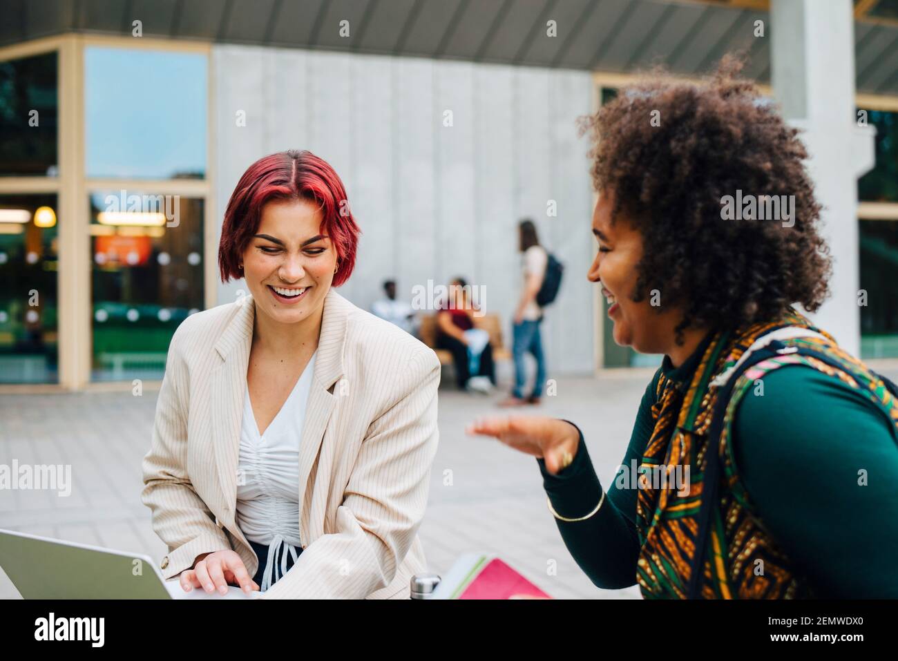 Studentinnen lachen beim gemeinsamen Studieren auf dem Universitätscampus Stockfoto