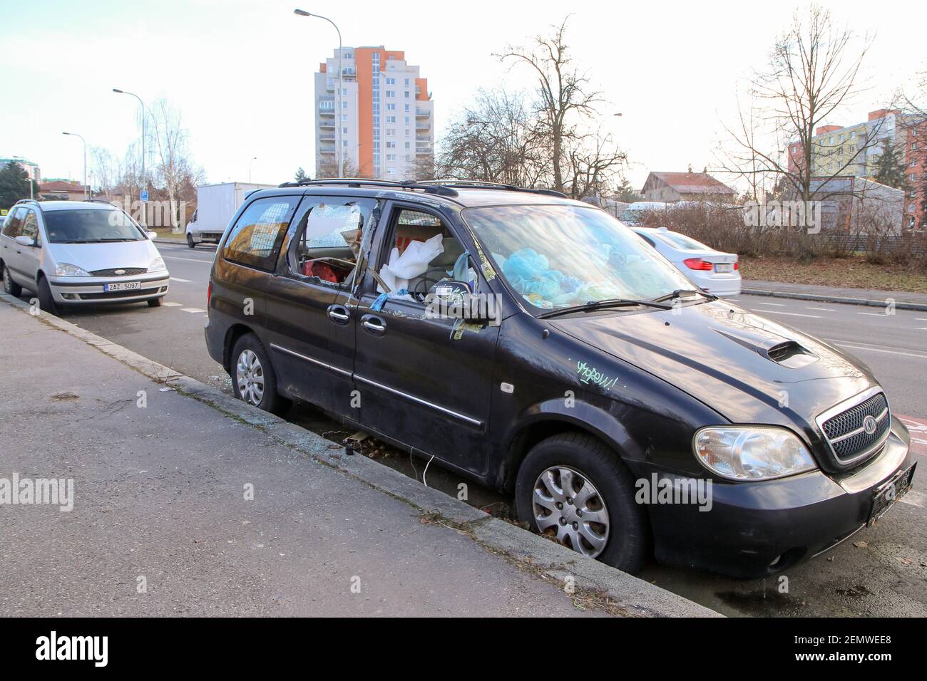 Das Detail eines verlassenen kaputten Autos, jetzt ein Wrack mit beschädigten oder gebrochenen Fenstern und voller Müll oder Abfall. Nimmt einen Parkplatz für den anderen Stockfoto