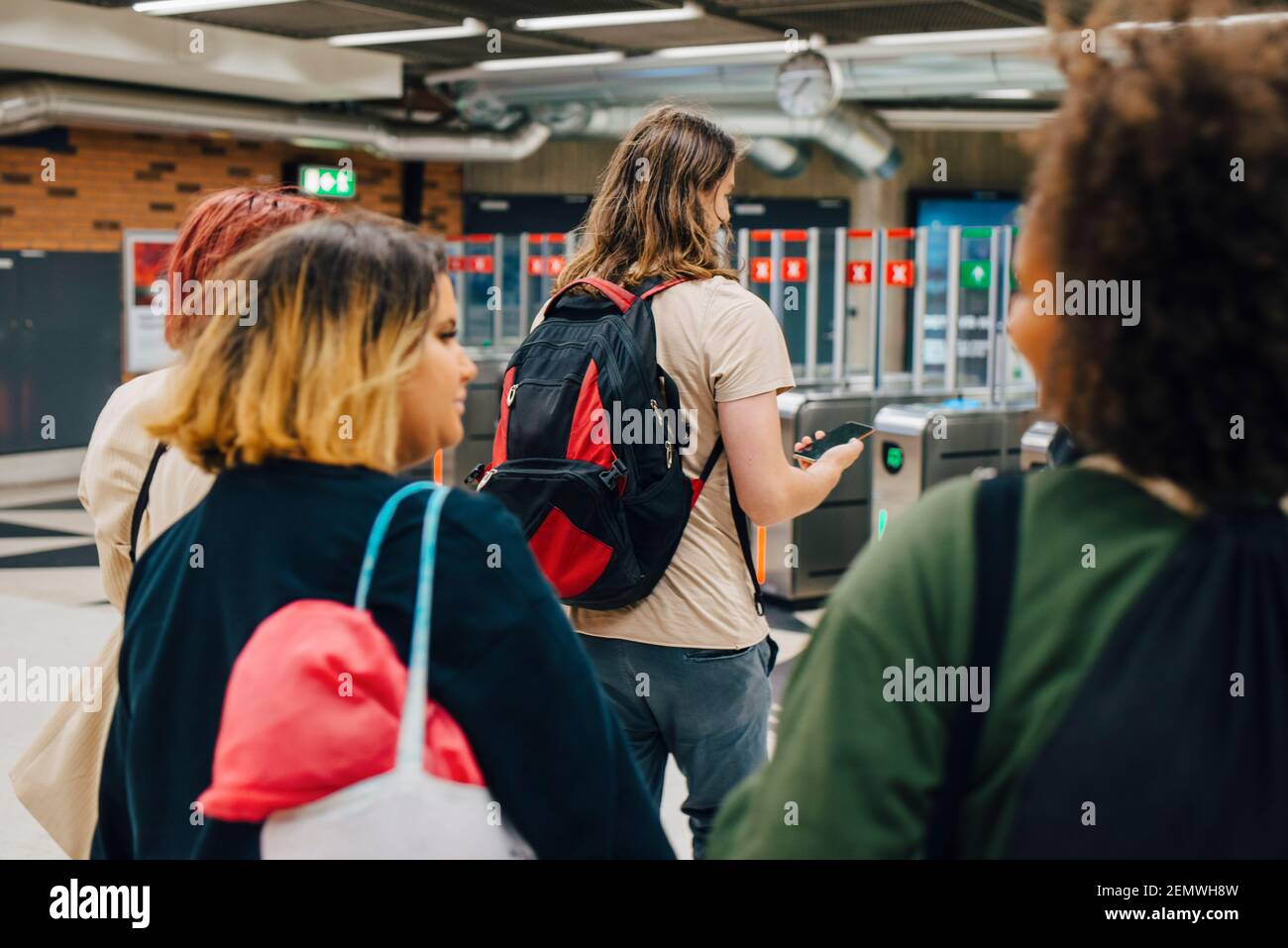 Rückansicht von Studenten, die an der U-Bahn-Station laufen Stockfoto