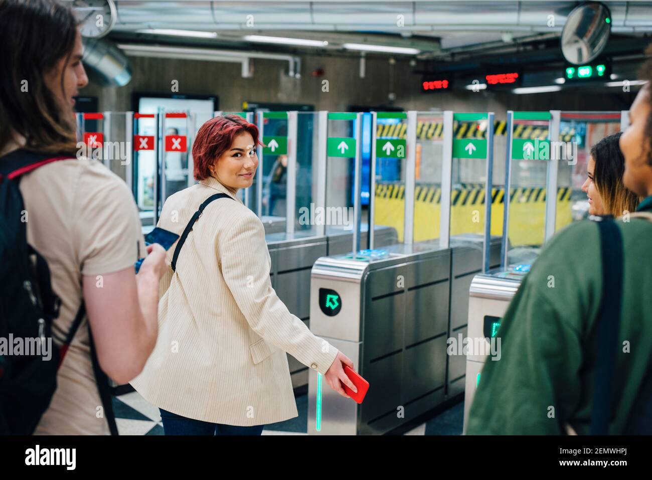 Porträt einer jungen Studentin, die über die Schulter auf die U-Bahn schaut Station Stockfoto