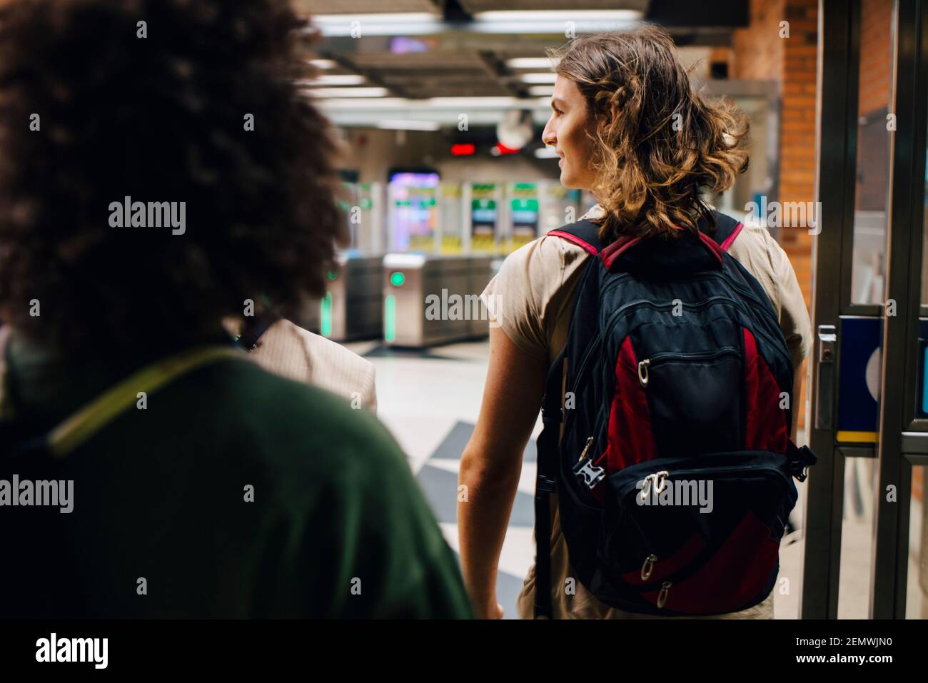 Rückansicht von männlichen und weiblichen Studenten, die an der U-Bahn spazieren Station Stockfoto