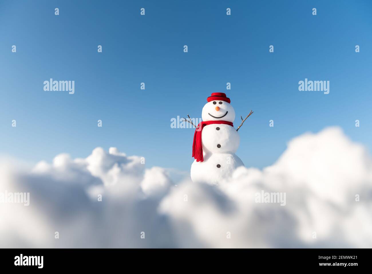Lustige Schneemann in stilvollen roten Hut und roten Skalf auf schneebedeckten Feld. Blauer Himmel auf dem Hintergrund Stockfoto