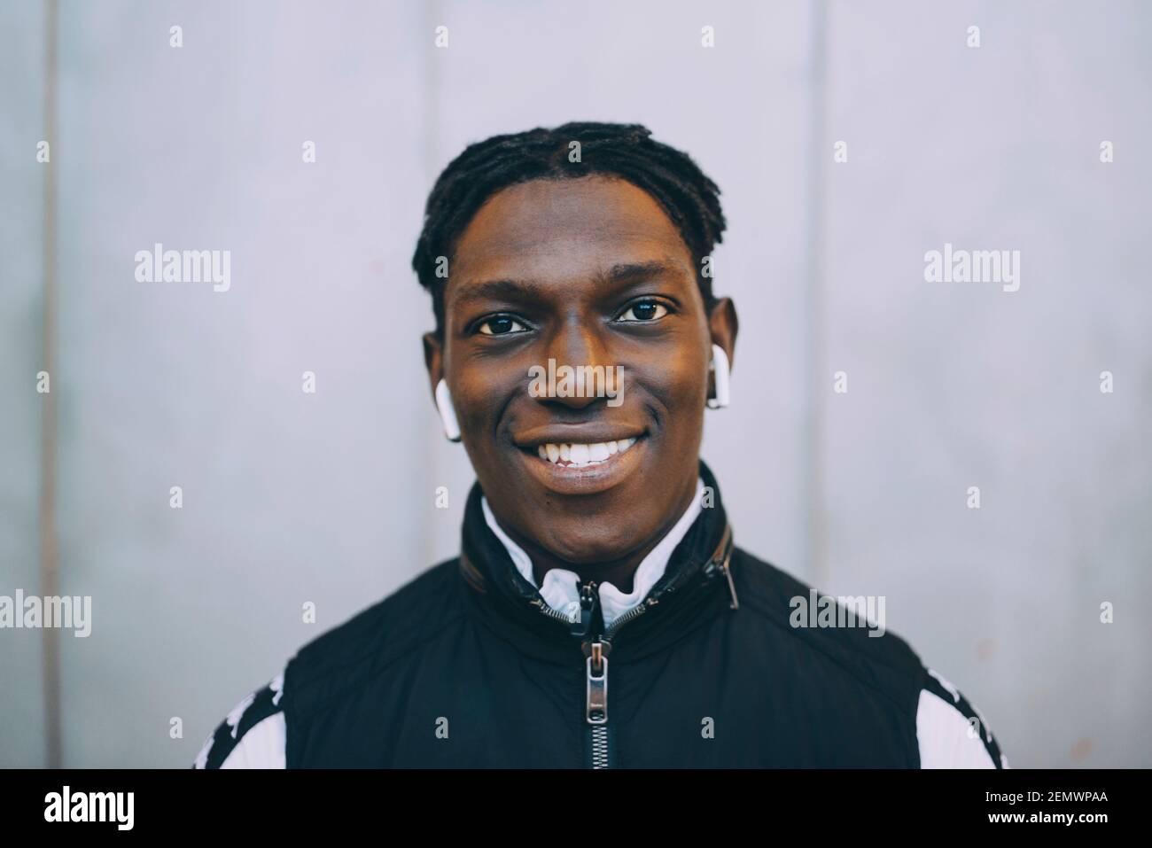 Porträt eines afrikanischen Studenten gegen graue Wand Stockfoto