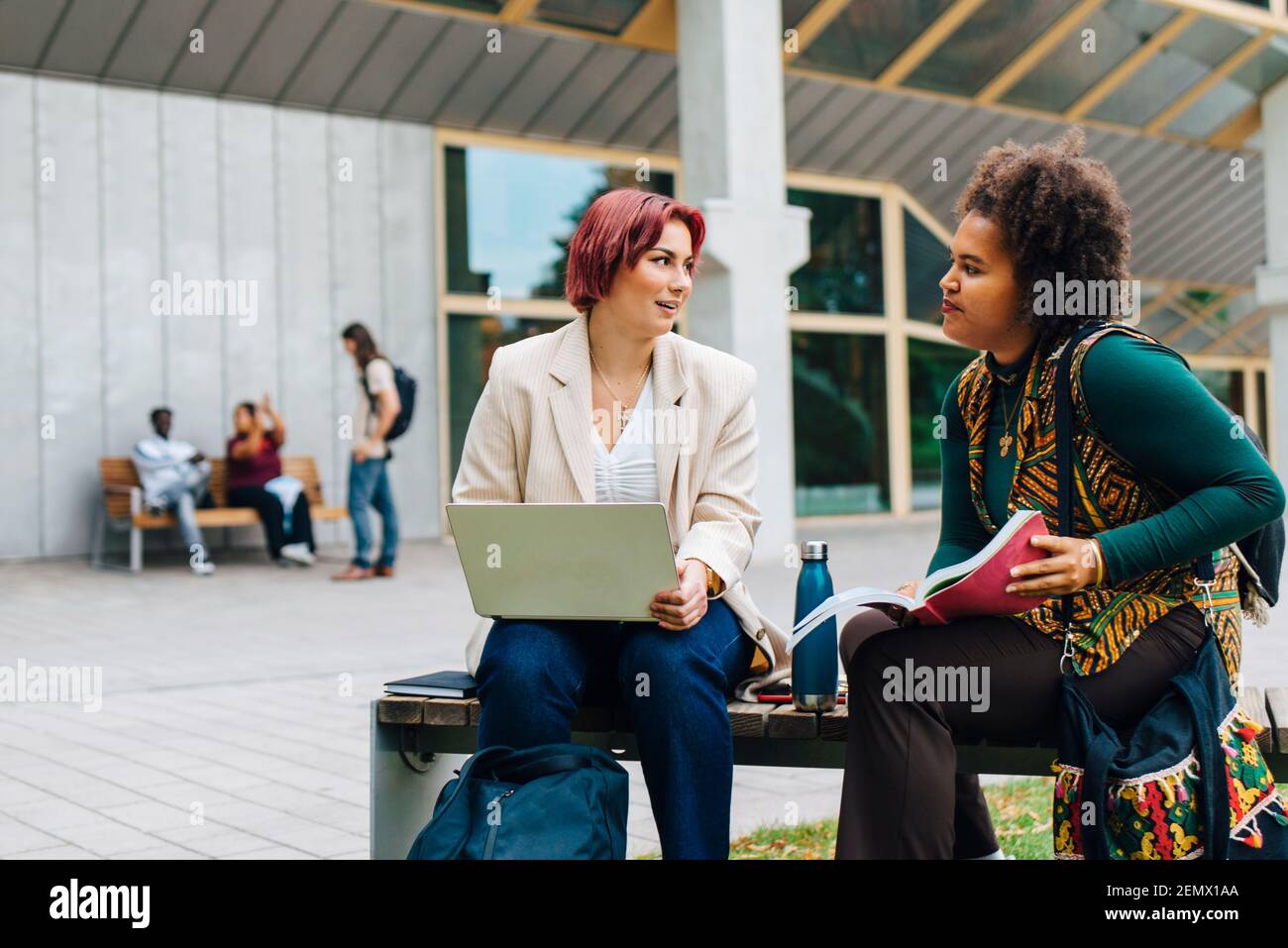 Studentinnen, die während des Studiums miteinander sprechen campus Stockfoto