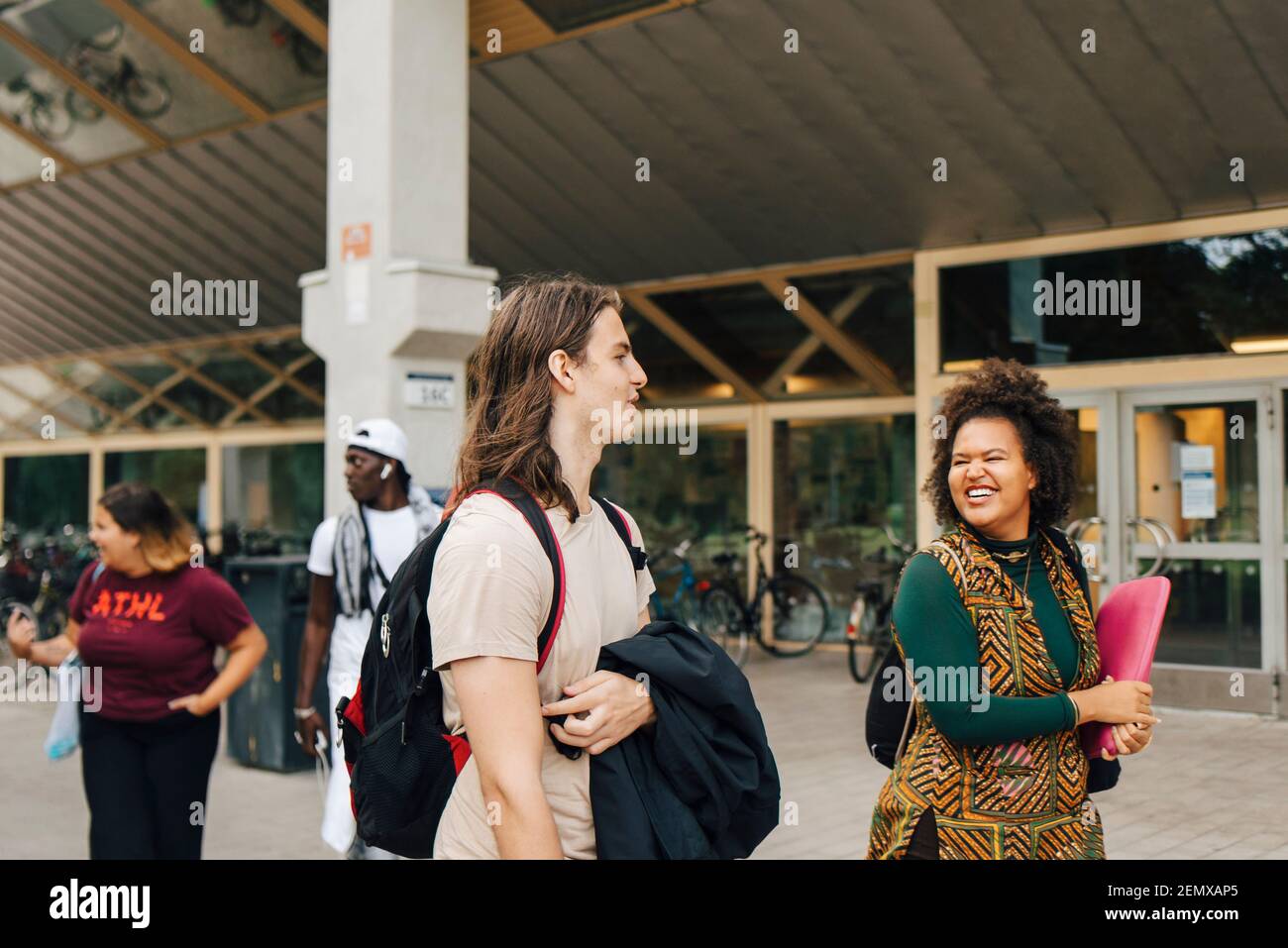 Männliche und weibliche Studenten zu Fuß in College-Campus Stockfoto