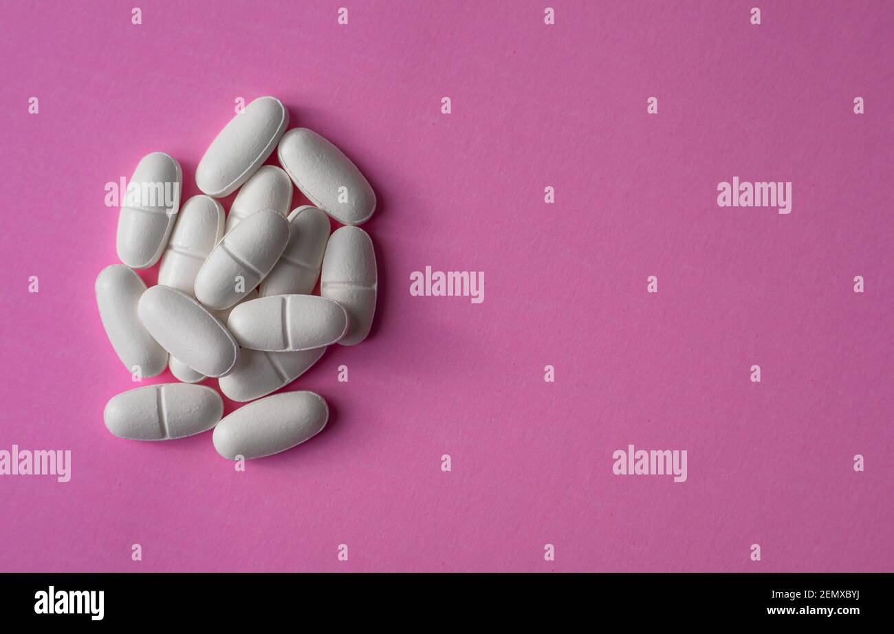Weiße große Pillen auf einem rosa Hintergrund Stockfoto