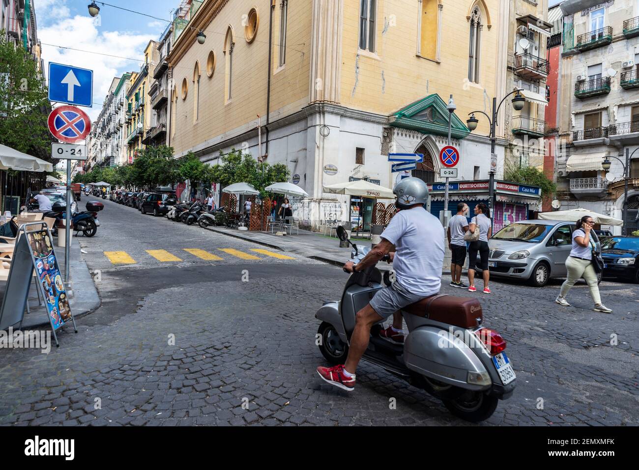 Neapel, Italien - 9. September 2019: Straße von alten Gebäuden mit einem Mann auf einer Vespa Motorrad in der Altstadt von Neapel, Italien Stockfoto
