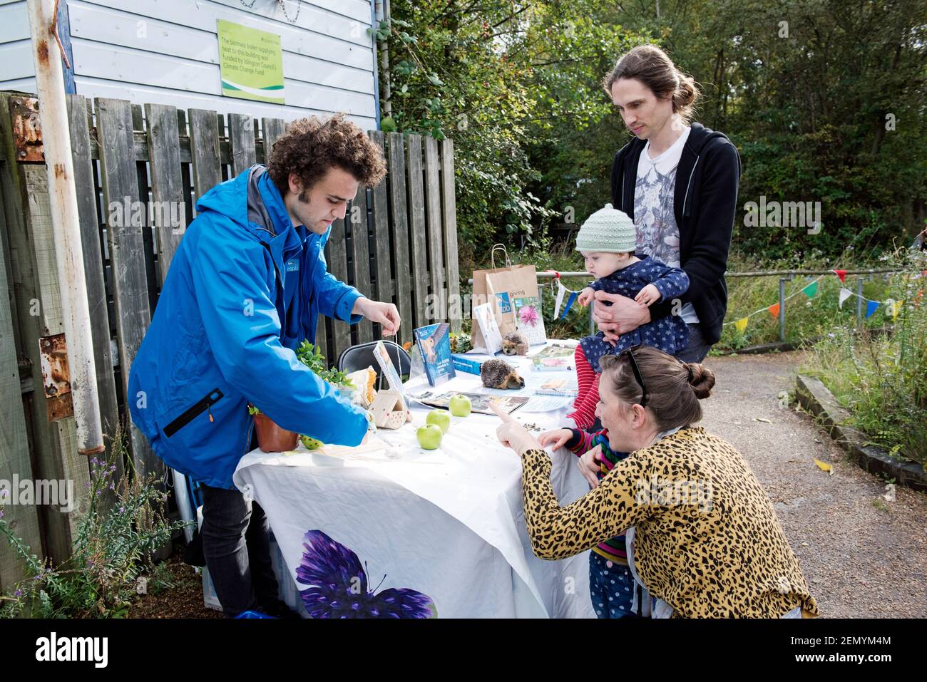 RSPB Stand mit Mann im Gespräch mit Familie einschließlich sehr kleines Mädchen, Apple Day, Gillespie Ökologie Park Stockfoto