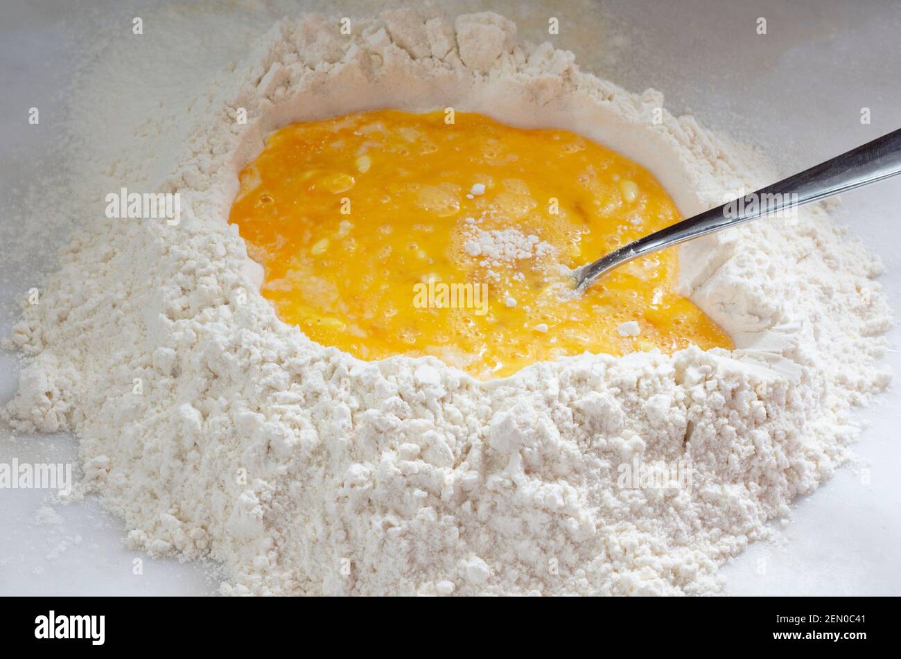 Hausgemachte Speisen, rohe Hühnereier und hausgemachte Pasta mit Mehl auf weißem Hintergrund. Stockfoto