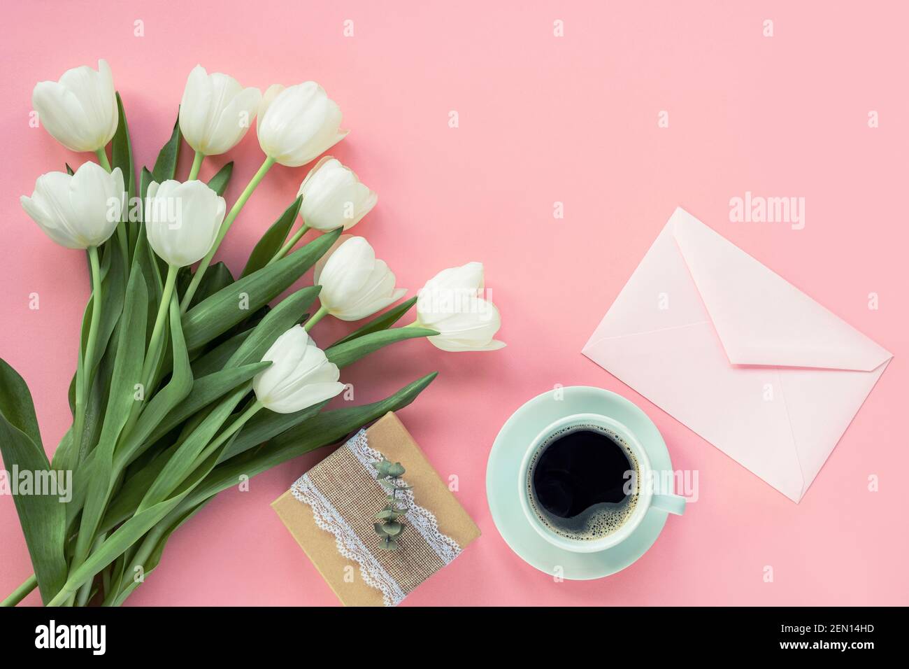 Tasse Kaffee, Geschenk in einer Schachtel und Blumenstrauß auf rosa Hintergrund, Draufsicht. Frauentag oder Muttertag Konzept. Flach liegend, Kopierplatz. Stockfoto