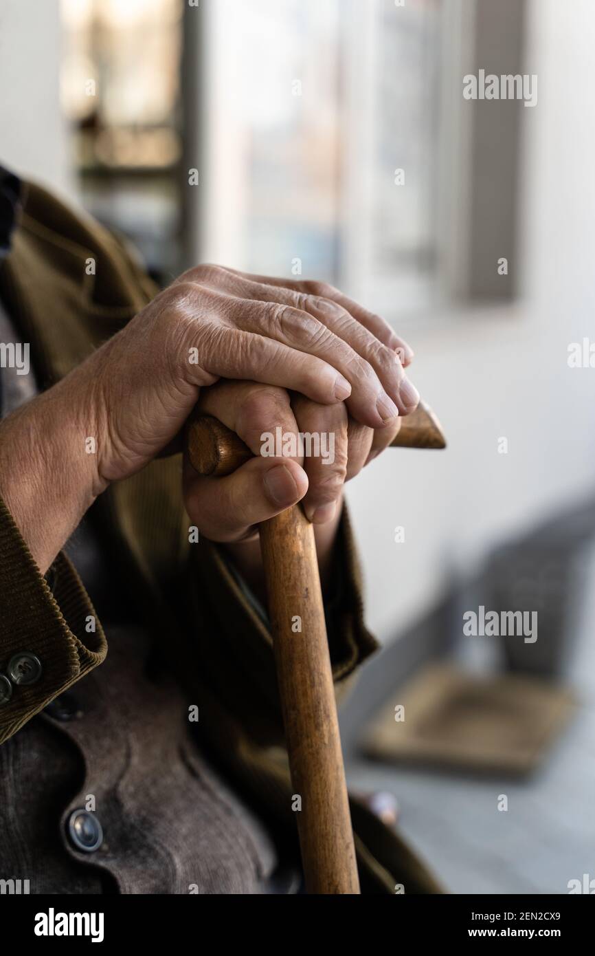 Nahaufnahme der Hände eines unbekannten alten kaukasischen Rentners Senior hält Stock Gehstock während sitzen und warten - Echte Menschen Alter Senilität Co Stockfoto