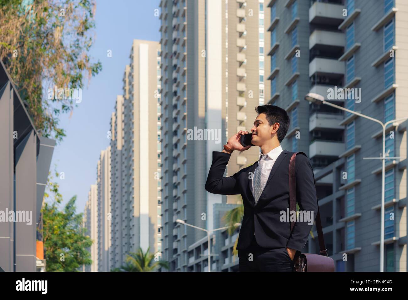 Asiatische Geschäftsmann steht und im Gespräch mit seinem Kollegen in Telefon auf den Straßen der Stadt während der morgendlichen pendeln. Stockfoto