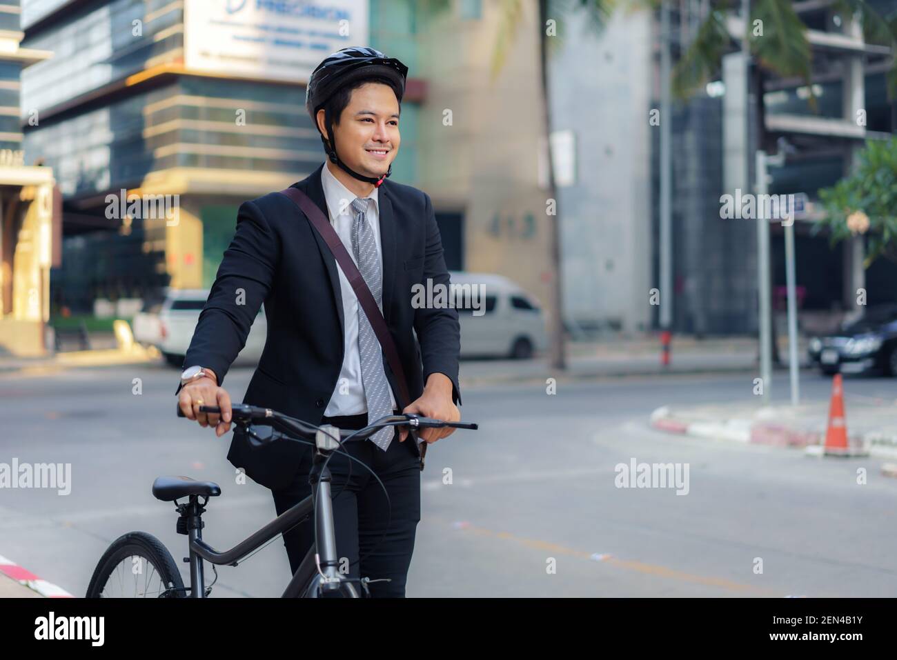 Asiatischer Geschäftsmann schiebt sein Fahrrad von zu Hause am Morgen Vorbereitung auf sein Fahrrad zur Arbeit zu fahren. Eco-Übertragung. Stockfoto