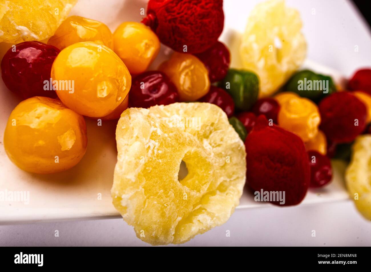 Ein Stapel mehrfarbiger kandierter Früchte auf einem weißen Teller und Hintergrund. Stockfoto