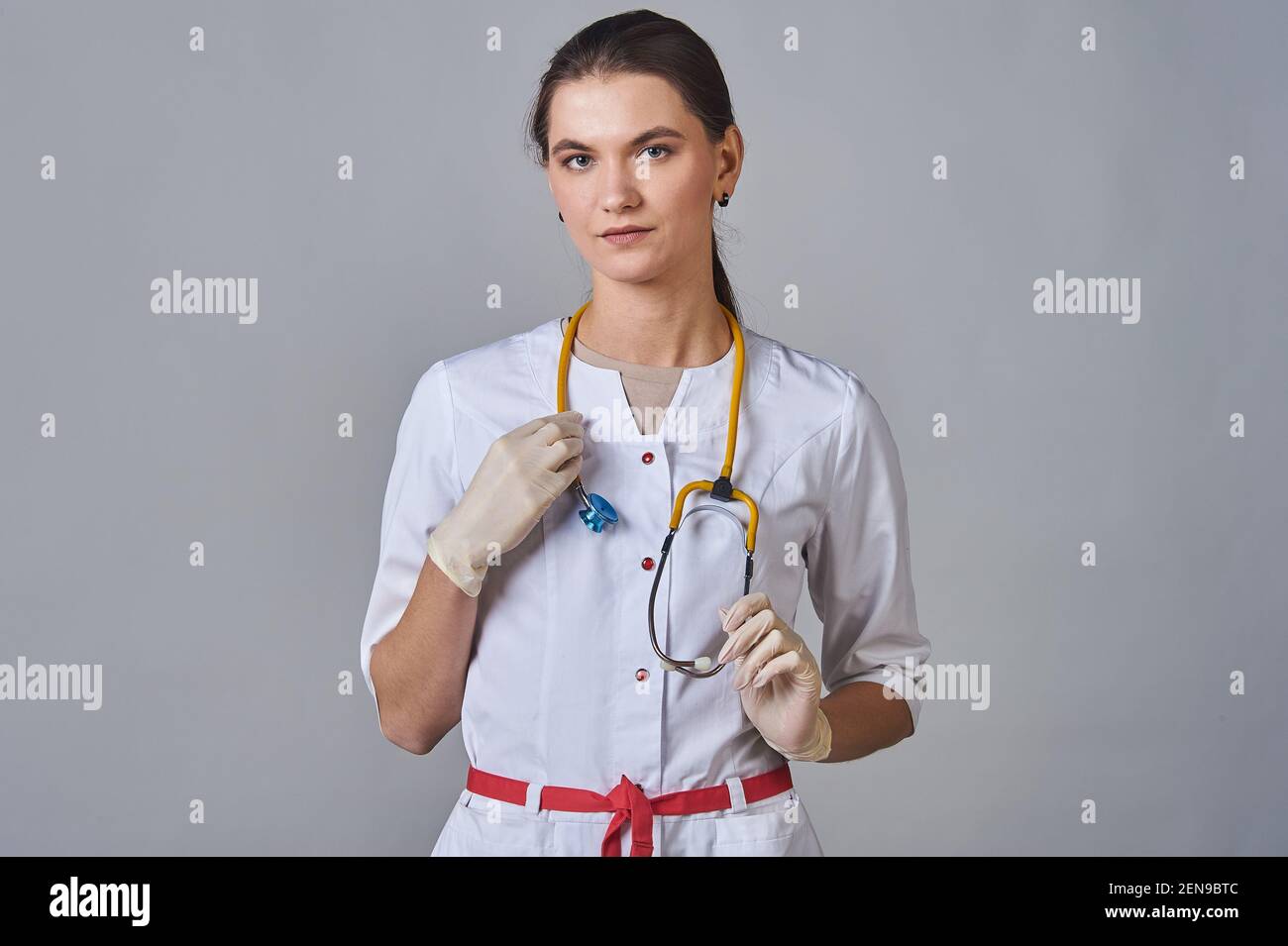 Junger Arzt im weißen Mantel mit einem gelben Stethoskop um Seinen Hals Stockfoto