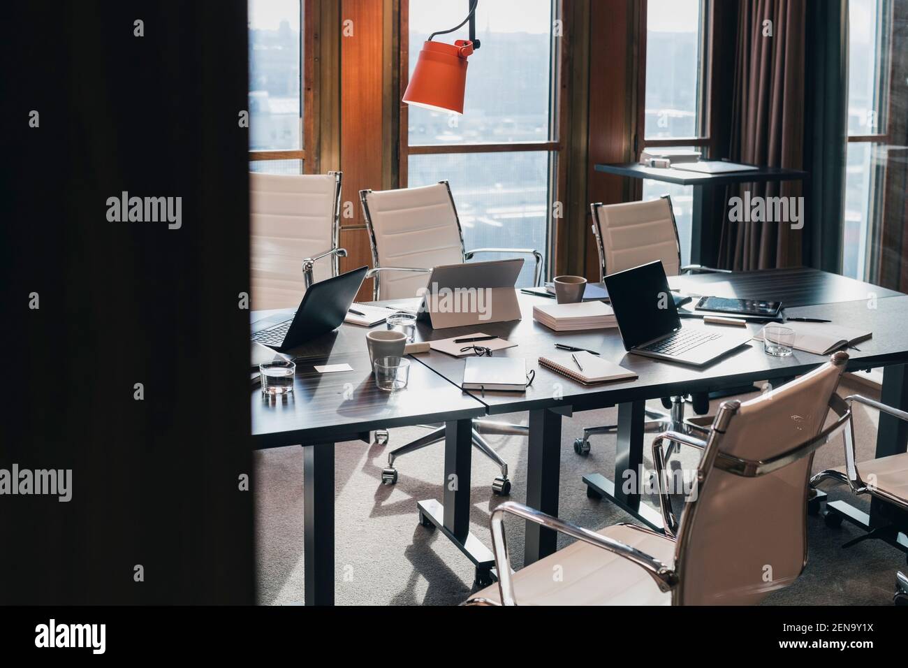 Drahtlose Technologien und Dokumente auf dem Konferenztisch im Sitzungssaal Im Büro Stockfoto