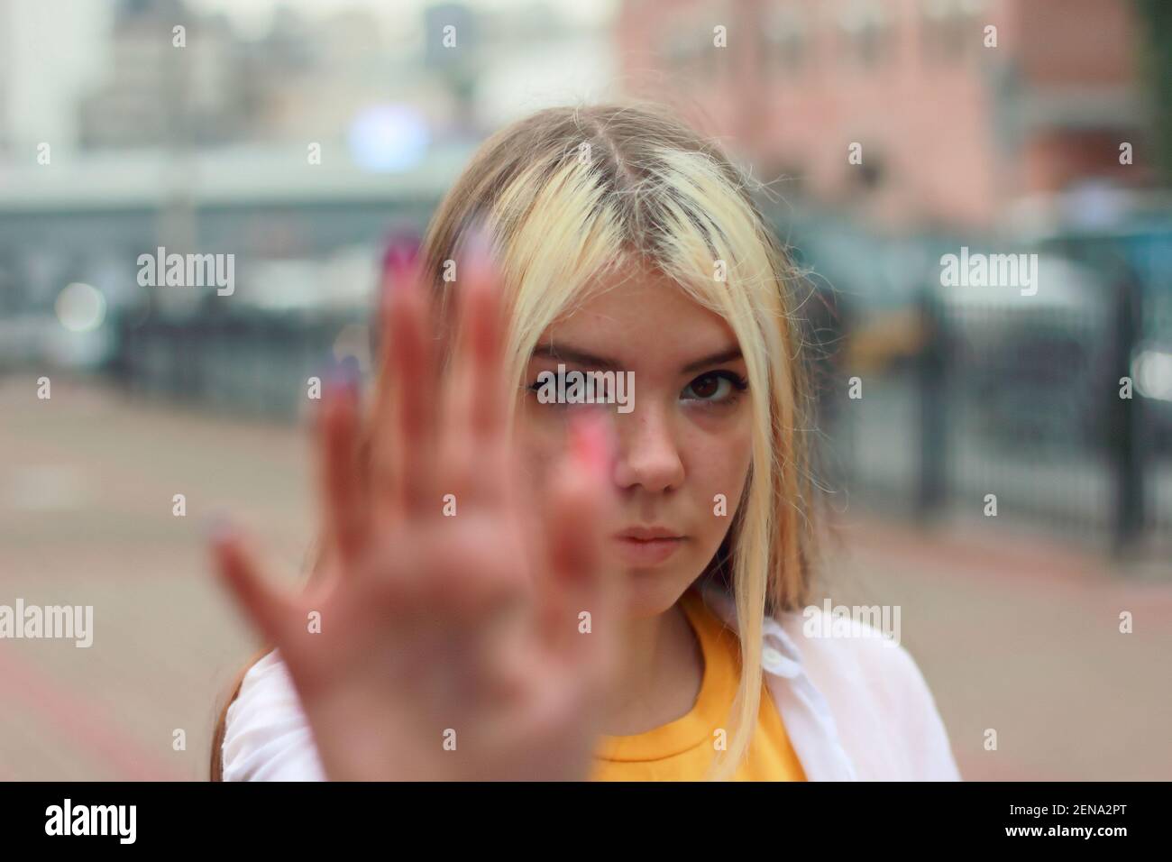 Junge Teenager-Mädchen mit blonden langen Haaren zeigt Stop-Zeichen Mit der Hand, die sie ansieht Stockfoto