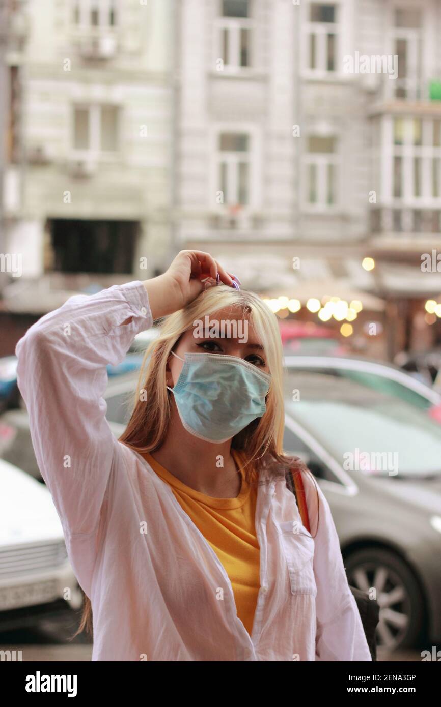 Blonde Mädchen mit langen Haaren in einer schützenden medizinischen Maske Während des Coronavirus Stockfoto