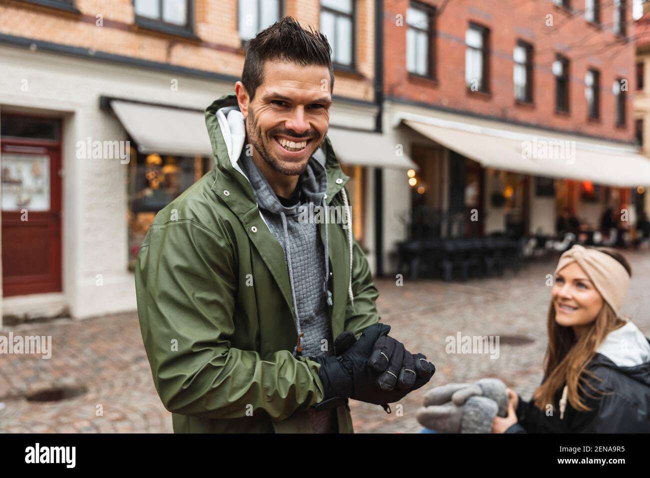 Porträt eines lächelnden Mannes mit Frau auf der Straße in der Stadt Stockfoto