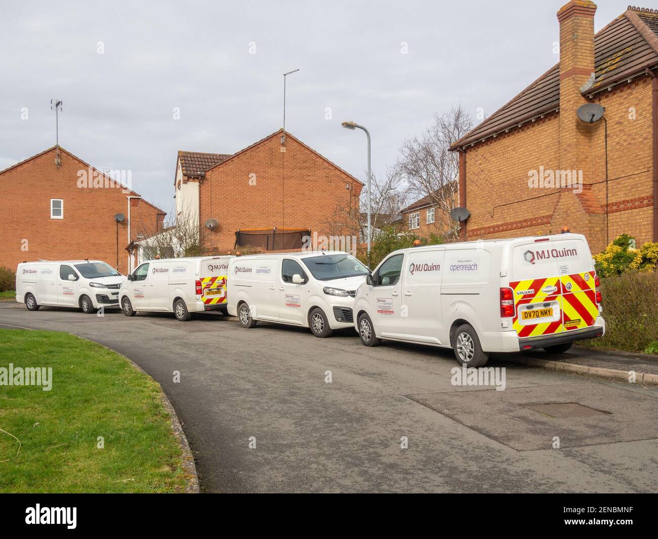 Vier weiße Openreach Subunternehmer Lieferwagen geparkt Nase an Schwanz auf einer Vorstadtstraße, Northampton, Großbritannien; fitting Faser Breitband zu einem Haus. Stockfoto