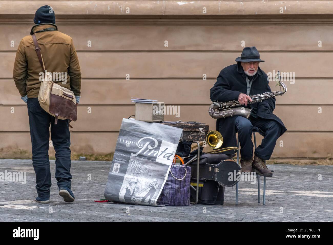 Prag, Tschechische Republik -19. Januar 2020: Alter Mann, Straßenmusiker mit Saxophonsitzen auf der Straße. Stockfoto