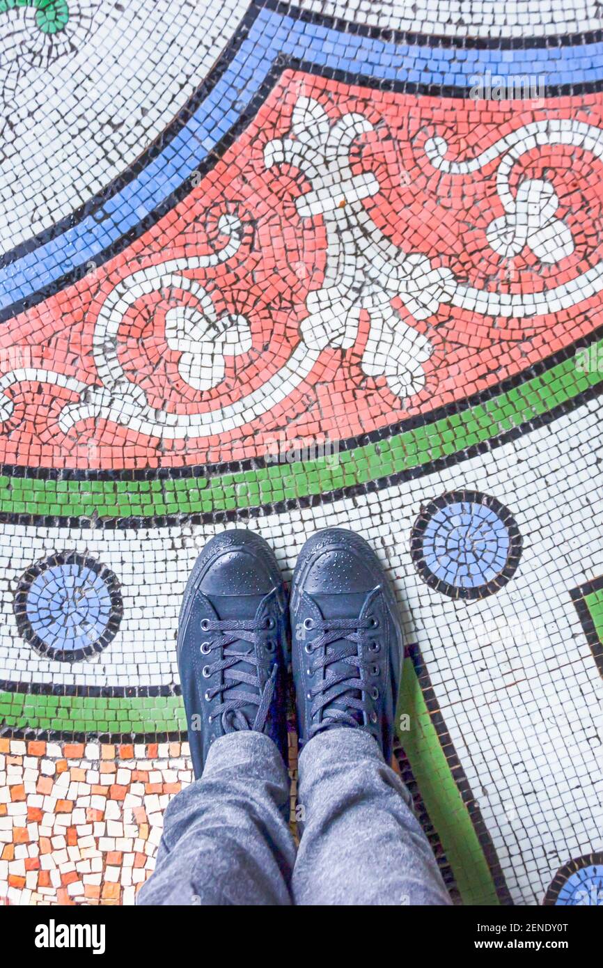 Füße Selfie mit schwarzen Schuhen auf bunt schönen Mosaikfliesen Boden, Draufsicht Stockfoto