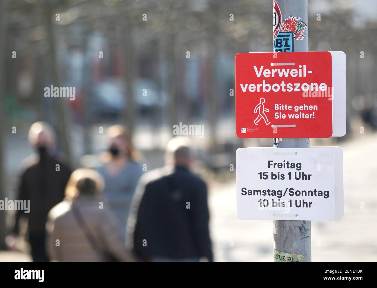 Düsseldorf, Deutschland. Februar 2021, 26th. Wanderer entlang der Rheinpromenade passieren Verbotsschilder mit den Worten 'Verweilverbotszone - Bitte gehen sie weiter' und 'Freitag 15 bis 1 Uhr - Samstag/Sonntag 10-1 Uhr'. Bis März 14 hat die Stadt Düsseldorf an Wochenenden eine "No-Stay-Zone" für die berühmte Altstadt und das nahe Rheinufer eingeführt. Die Menschen dürfen nicht länger anhalten, sich hinsetzen oder sich fast den ganzen Tag lang auf einer Rasenfläche hinlegen. Quelle: Roland Weihrauch/dpa/Alamy Live News Stockfoto