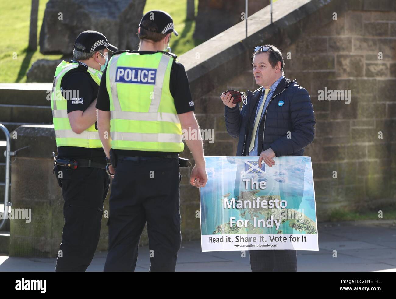 Ein Unterstützer der Unabhängigkeit spricht vor dem schottischen Parlament mit der Polizei, da der ehemalige erste Minister Alex Salmond einem Schottischen Ausschuss für Belästigung des Parlaments, der den Umgang mit Belästigungsvorwürfen bei Holyrood in Edinburgh prüft, Beweise vorlegen soll. Bilddatum: Freitag, 26. Februar 2021. Stockfoto