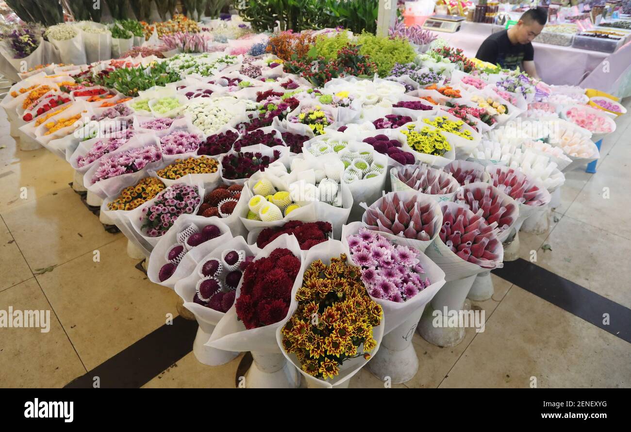 Chinesische Arbeiter zeigen Blumen auf einem Blumenmarkt vor dem