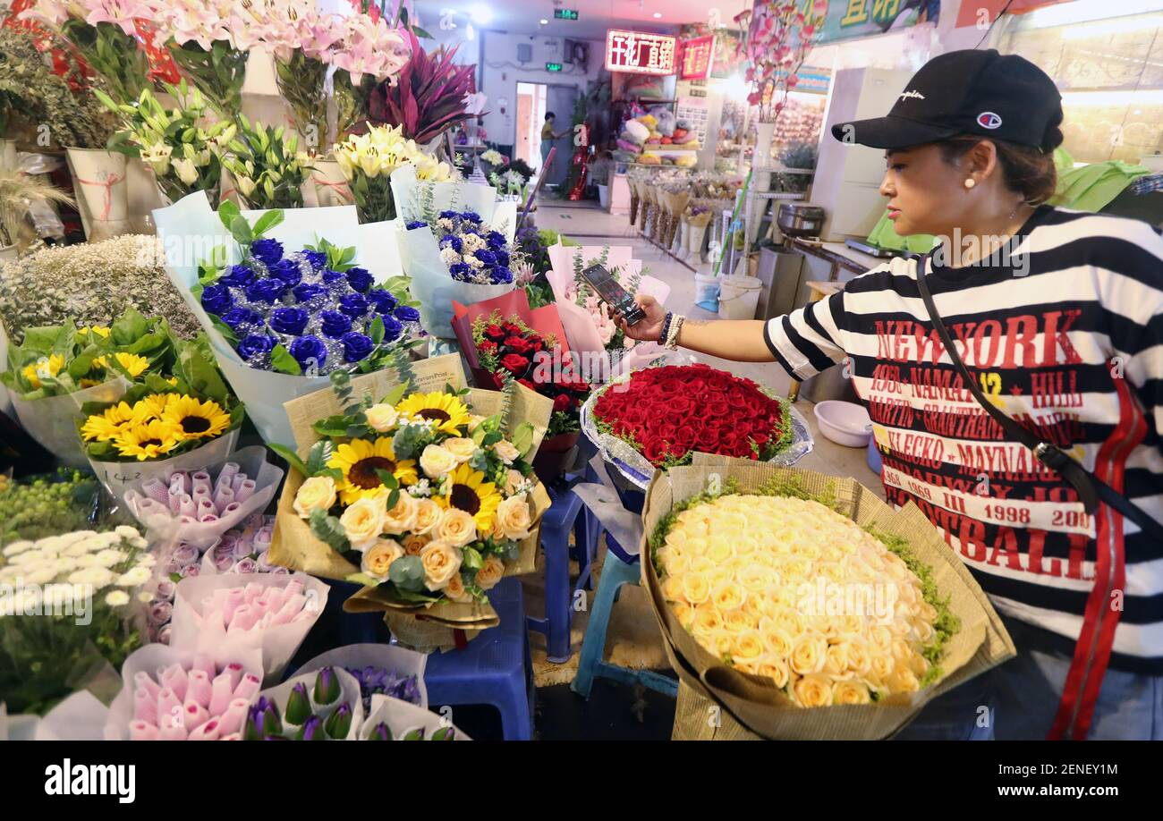 Chinesische Arbeiter zeigen Blumen auf einem Blumenmarkt vor dem