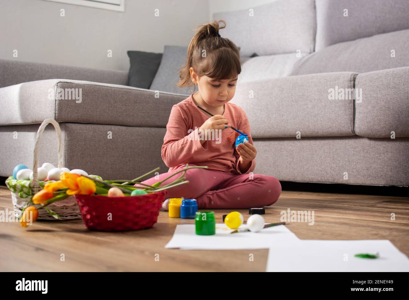 Baby Mädchen Malerei Ostereier zu Hause. Stockfoto