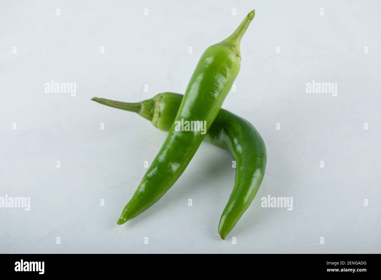 Zwei scharfe grüne Chilischoten auf weißem Hintergrund Stockfoto