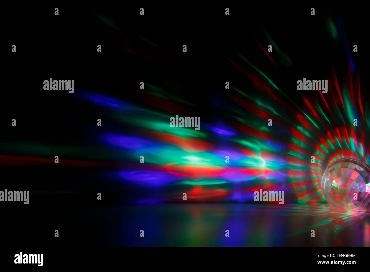 Bunte rote, grüne und blaue Lichtstrahlen oder Lichtstrahlen und eckige transparente Kugel bei Dunkelheit. Abstrakter, hochauflösender Hintergrund. Stockfoto