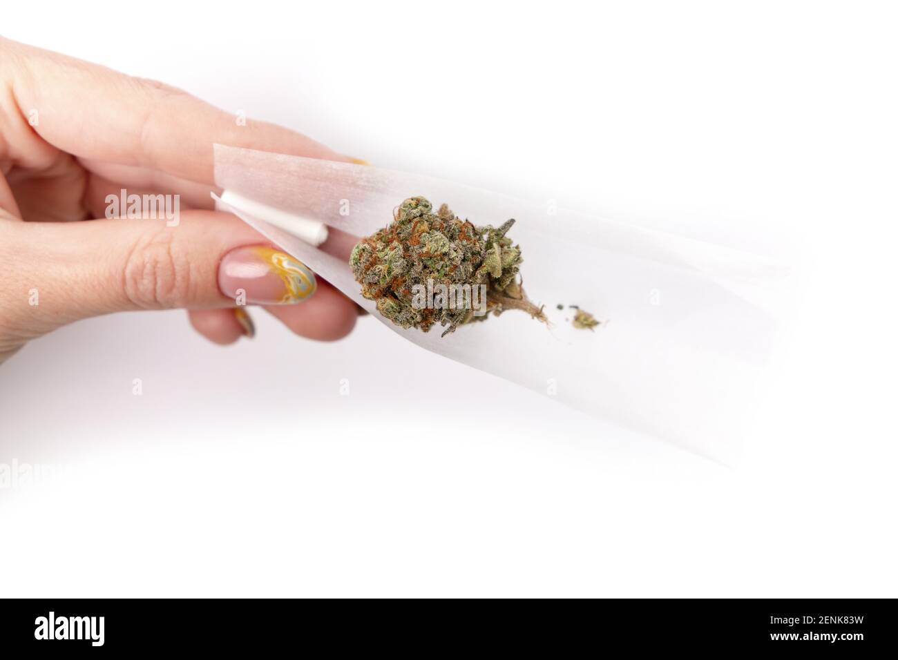 Draufsicht auf weibliche Hand, die Papier mit medizinischem Marihuana auf weißem Hintergrund isoliert hält. Hochwertige Fotos Stockfoto