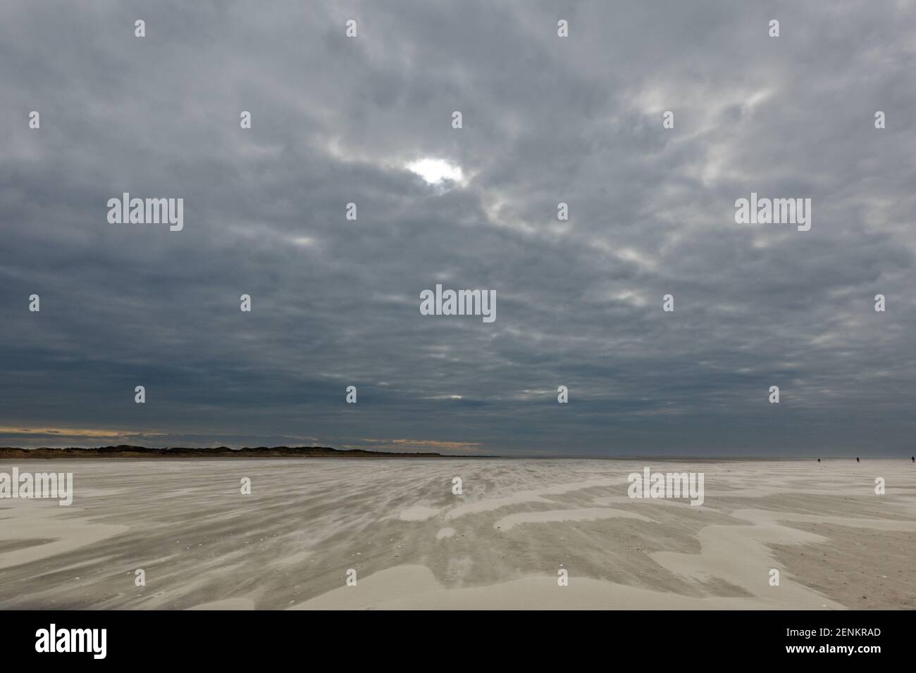 Sturm weht Sand über den riesigen Strand unter einem dunklen Himmel im Winter Stockfoto