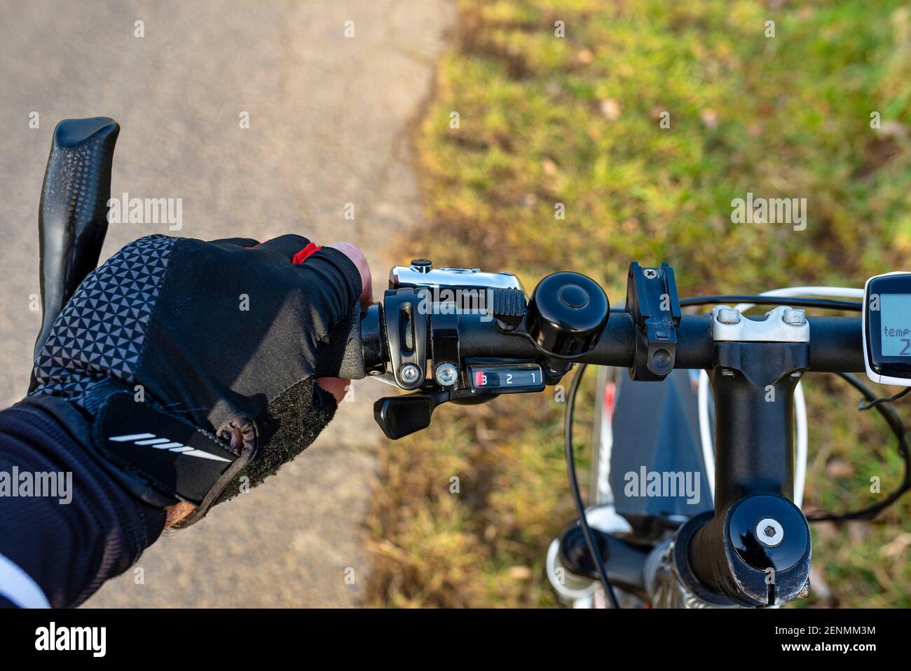 Ein Fahrradlenker aus der Perspektive der ersten Person und mit einer mans  Hand am Griff. Sichtbarer Fahrradcomputer und Glocke Stockfotografie - Alamy
