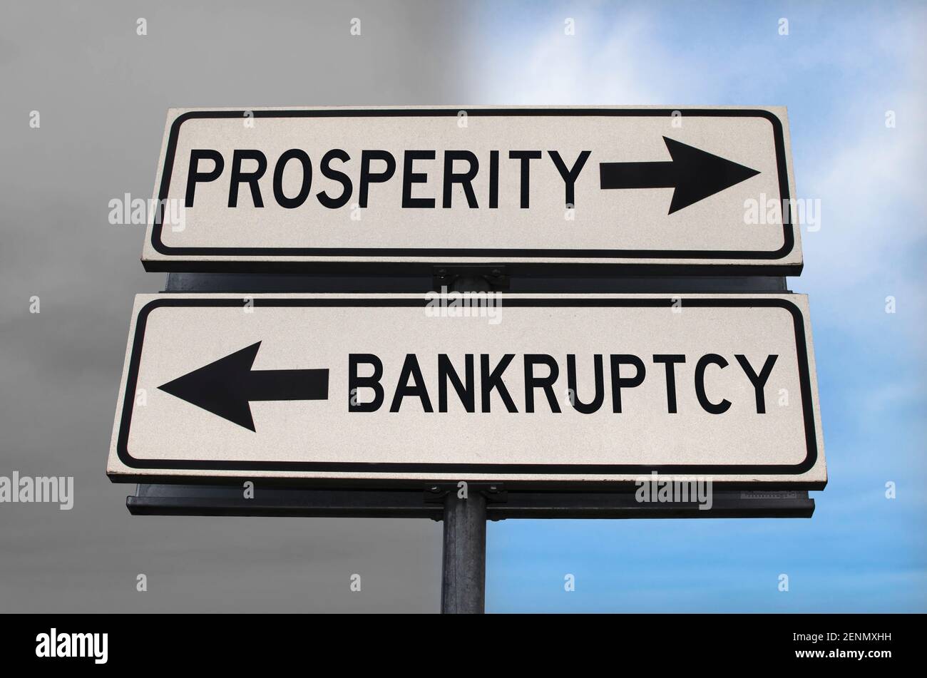 Prosperity versus Insolvenz Straßenschild mit zwei Pfeilen auf blauem und grauem Himmel Hintergrund. Weißes zwei Straßenschild mit Pfeilen auf Metallmast. Zwei Wege Stockfoto
