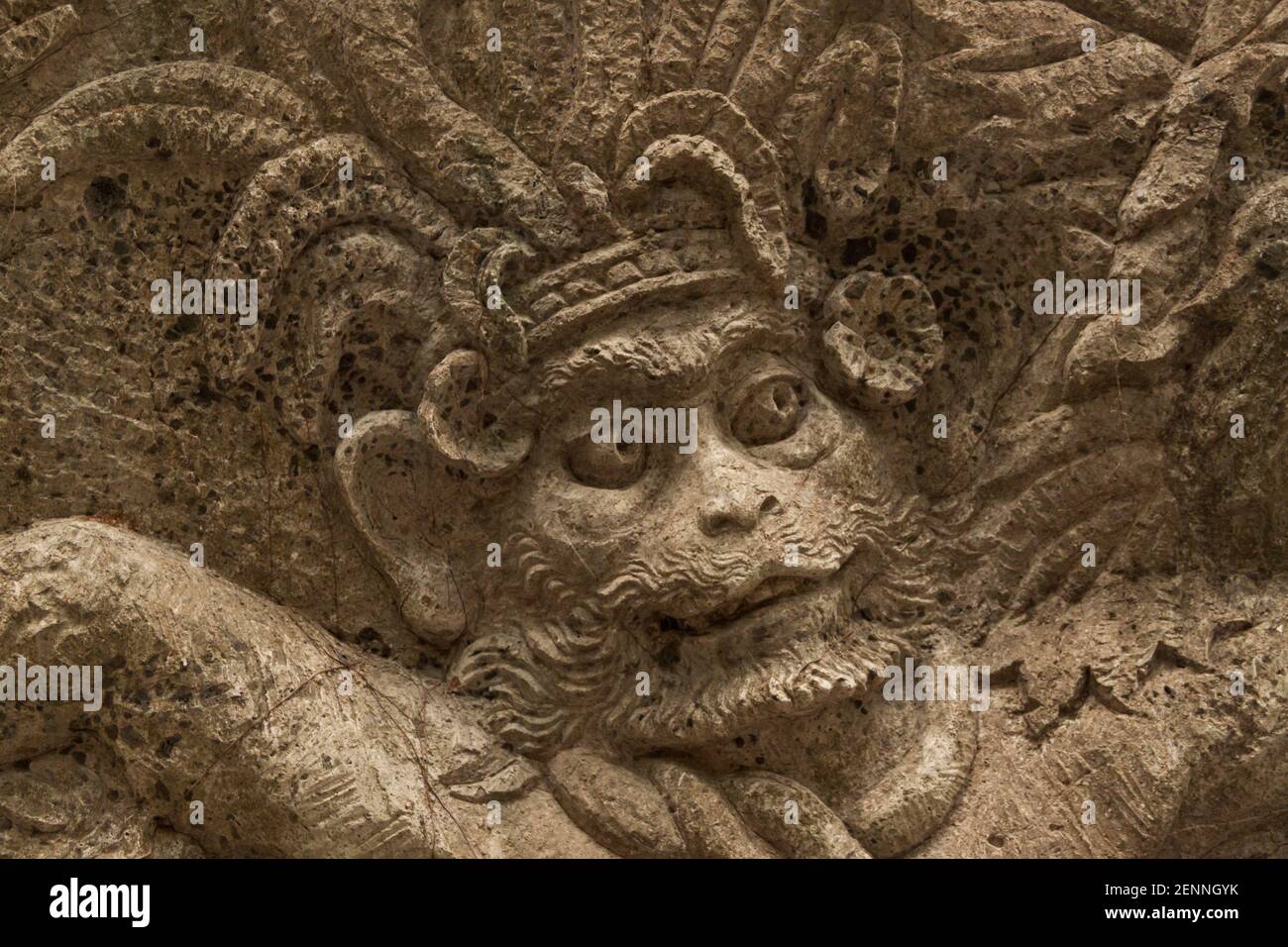 Nahaufnahme des Gesichts einer geschnitzten Figur des Hindu-gottes An einer Wand in der Nähe des Heiligen Affenwaldes in Bali Stockfoto