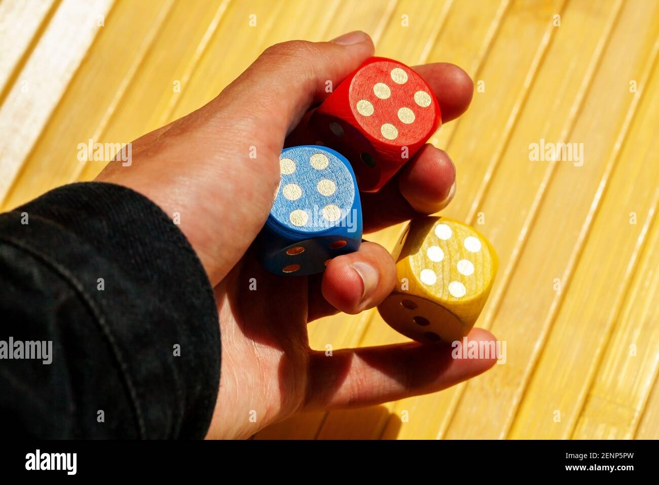 Lucky Spieler Hand hält drei bunte glänzende Spielwürfel mit der Nummer sechs. Mehrere Würfel zeigen 6, Glück im Glücksspiel, Betrug, Dodger, ass die sle Stockfoto