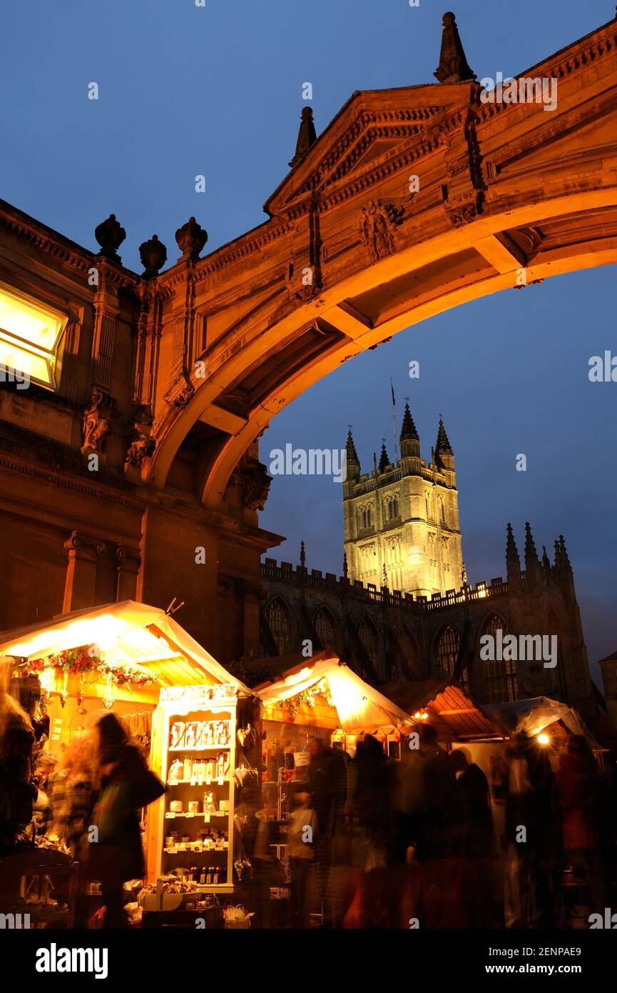 Bath Abbey und The Cloisters Archway mit Einkäufern auf dem Weihnachtsmarkt in Bath, Großbritannien. Stockfoto