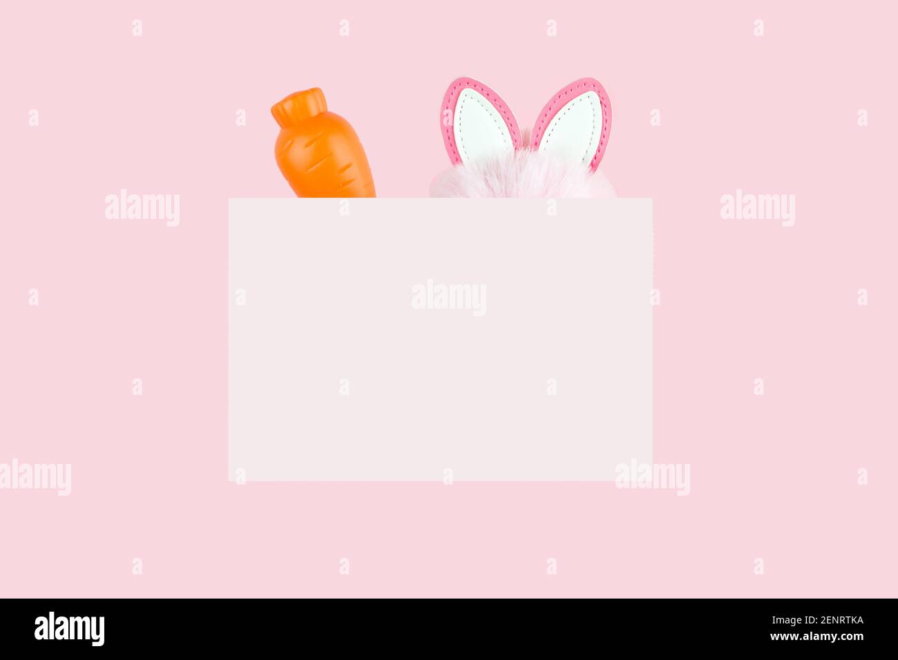 Emblem mit Karotte und Hasenohren auf rosa. Design für Frühlingsferien Stockfoto