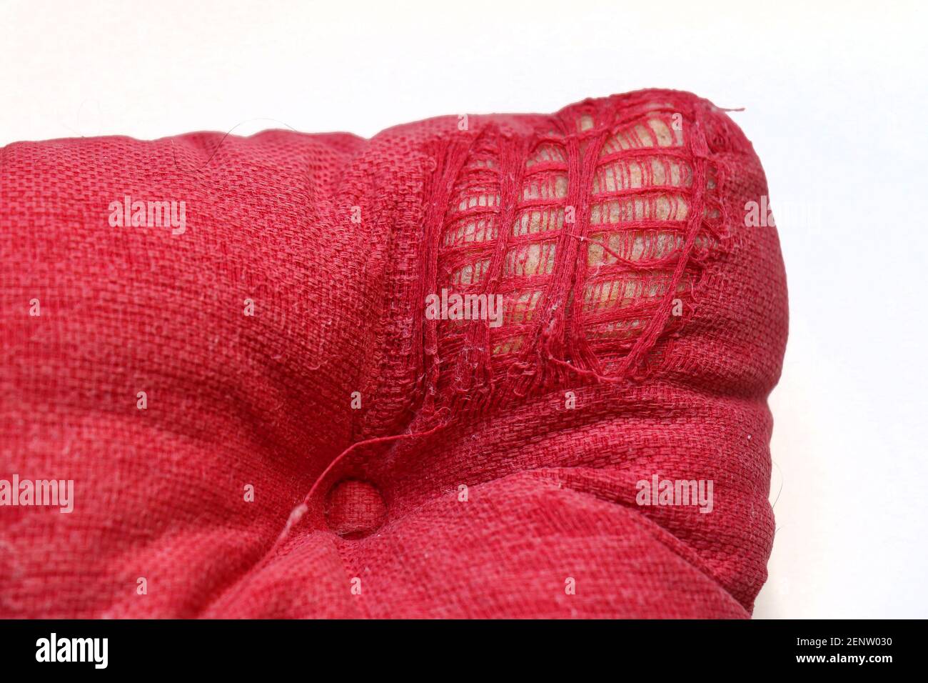 Zerrissene Textil ruiniert zerfetzt rote Kissen Ecke Stockfoto