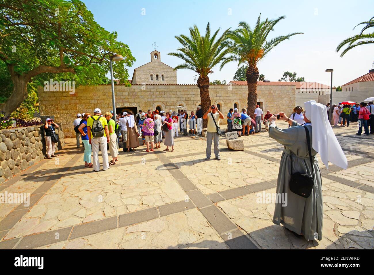 Eine Nonne fotografiert Touristen und Kirchen in Kapernaum, Israel Stockfoto