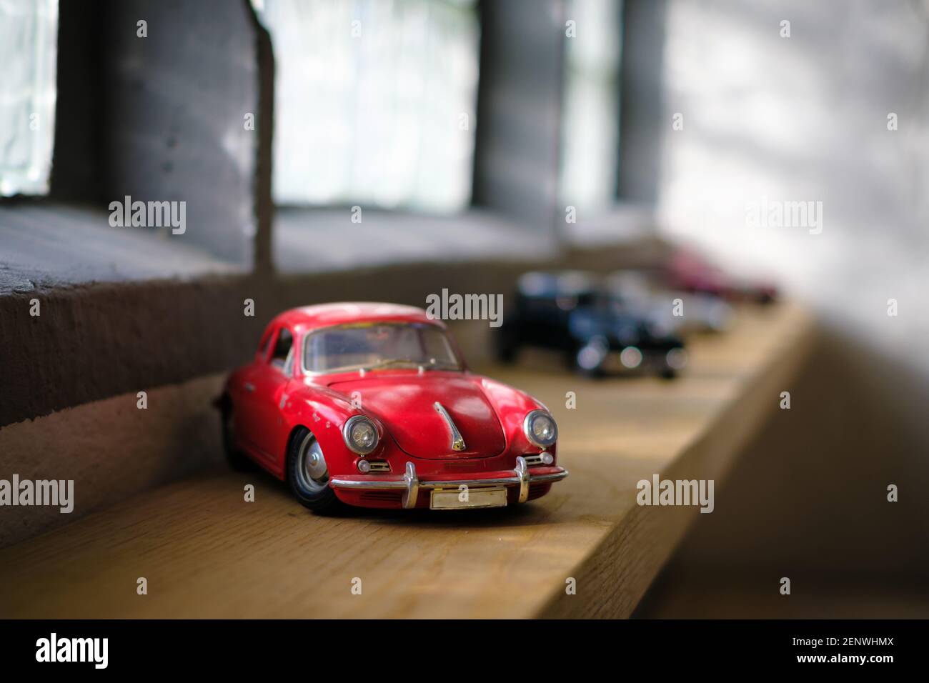 Auf einer Fensterbank befinden sich mehrere Oldtimer Stockfoto