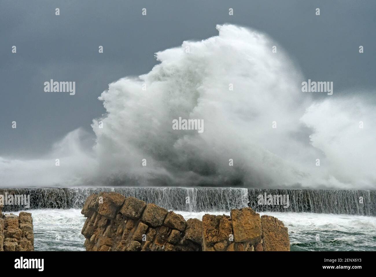 Wellenbruch an der Steinmauer in einem stürmischen Wintertag Stockfoto