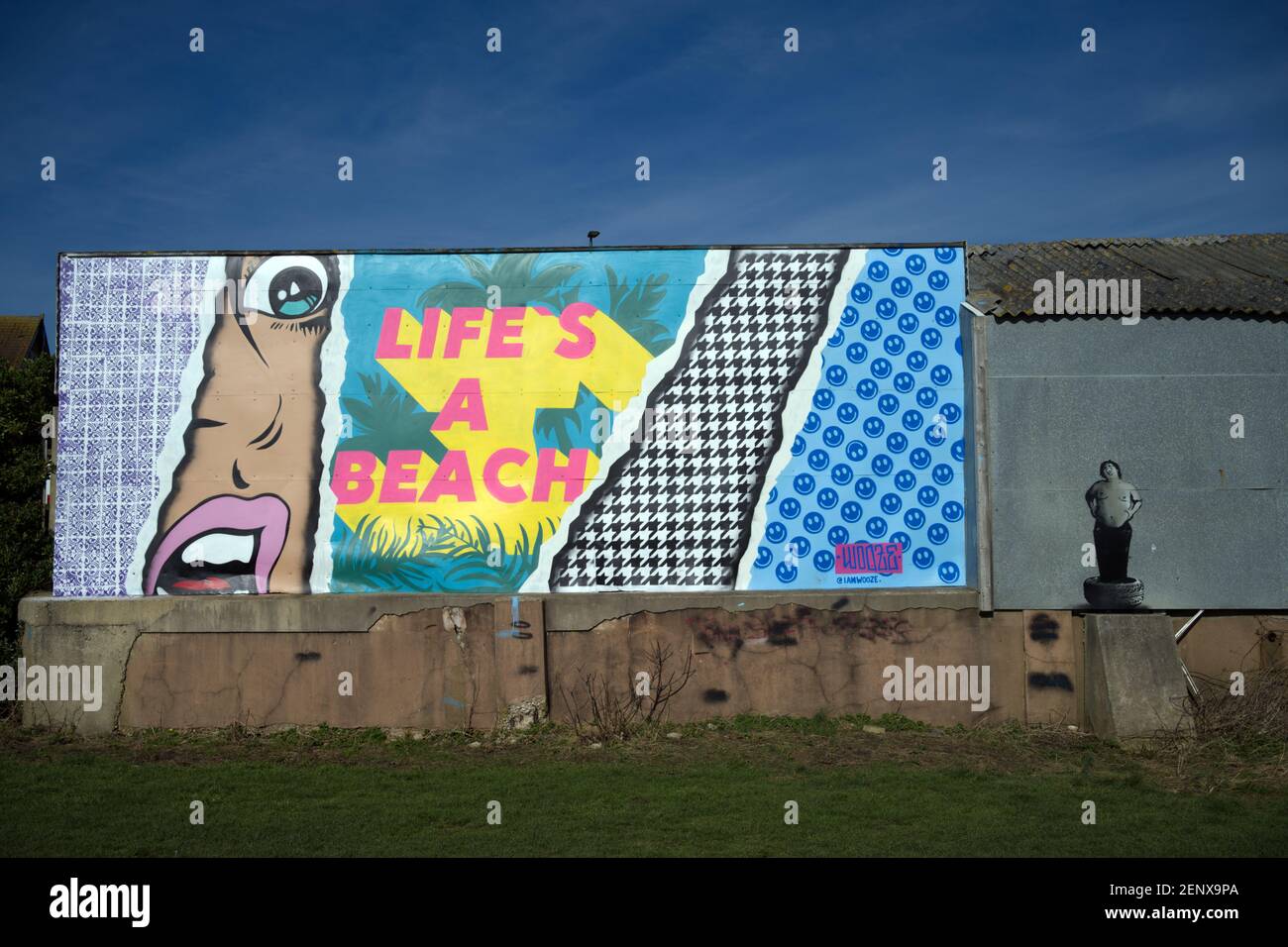 Street Art Hell Coloured Life ist ein Strand und ein portly Reifenmonteur hinter Lancing Beach. Stockfoto