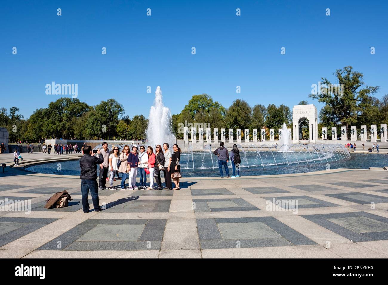 Gruppe von asiatischen Touristen posiert für ein Foto an der World war II Memorial Wasserbrunnen, National Mall, Washington D.C., USA. Stockfoto